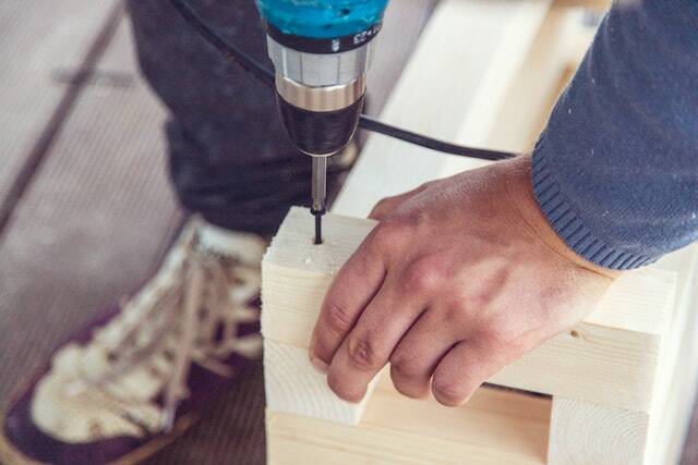 contractor drilling into a piece of wood to make a repair